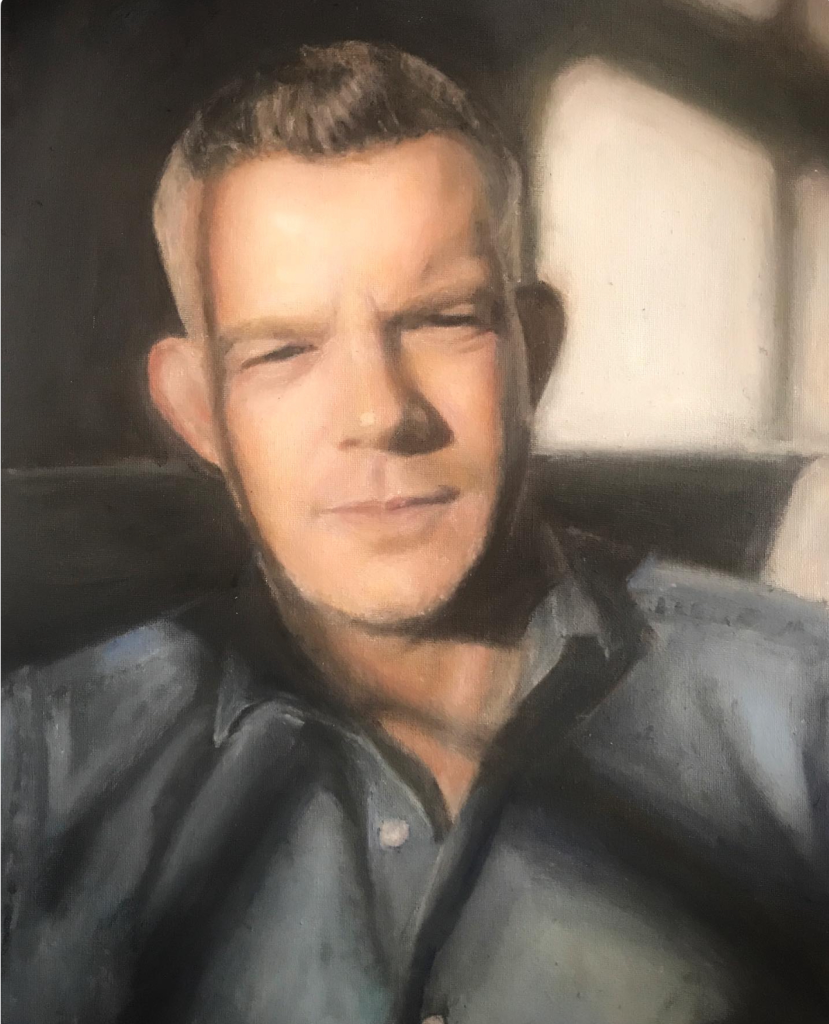 Oil portrait painting of Russell Tovey in soft sunlight wearing a blue shirt by Irish artist Deirdre Hayes