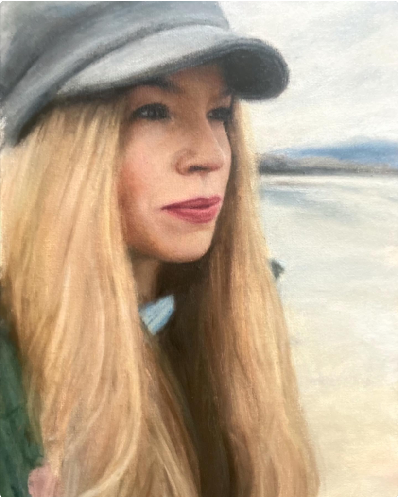 Self-portrait of artist Deirdre Hayes  outdoors in Castlegregory while wearing a grey cap on stradbally beach. 